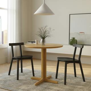The Odie Café Table x Ulka Dining Chair Bundle, contains products [Odie Café Table - Natural Oak] and [Ulka Dining Chair - Black].