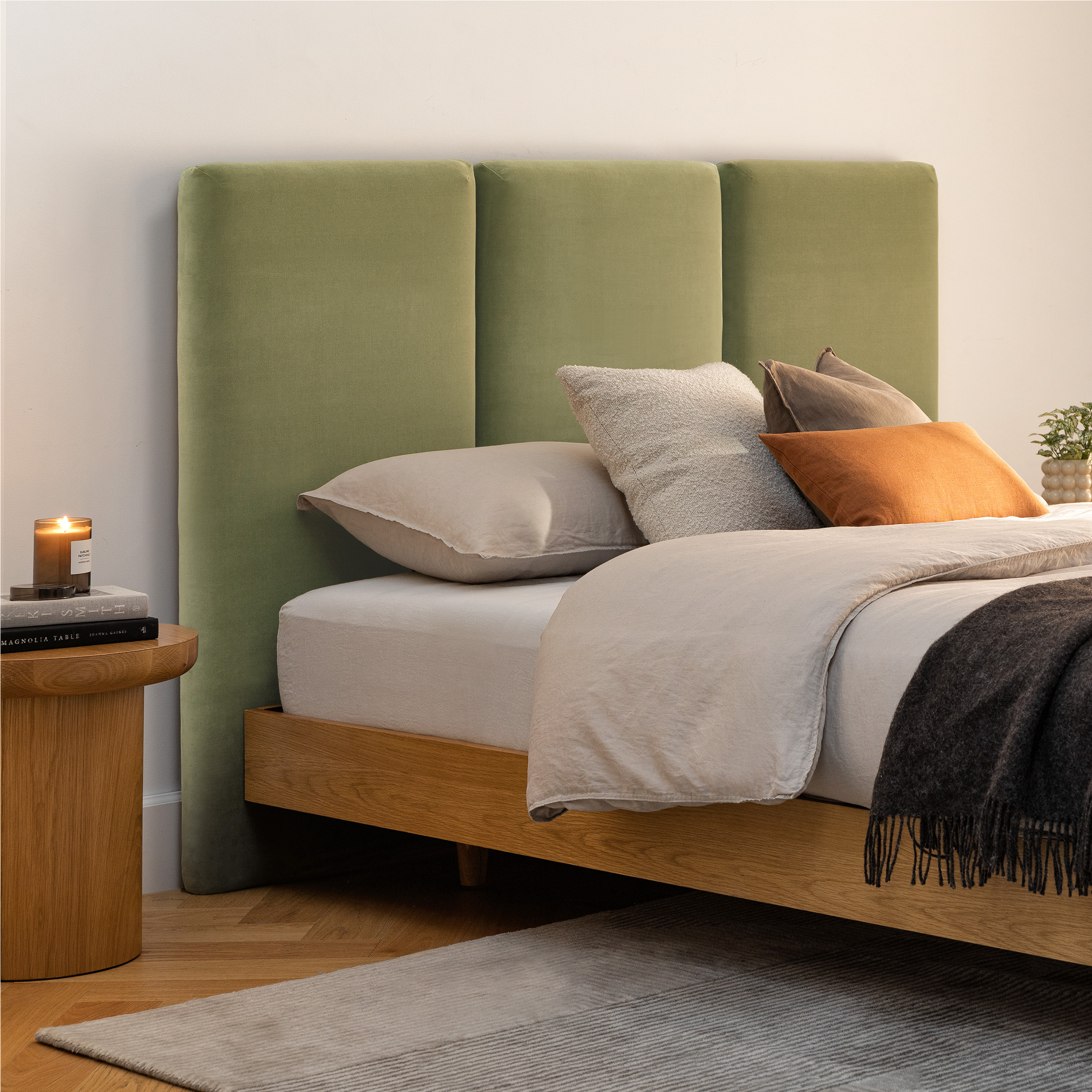 Sage green upholstered headboard as bedroom focal point